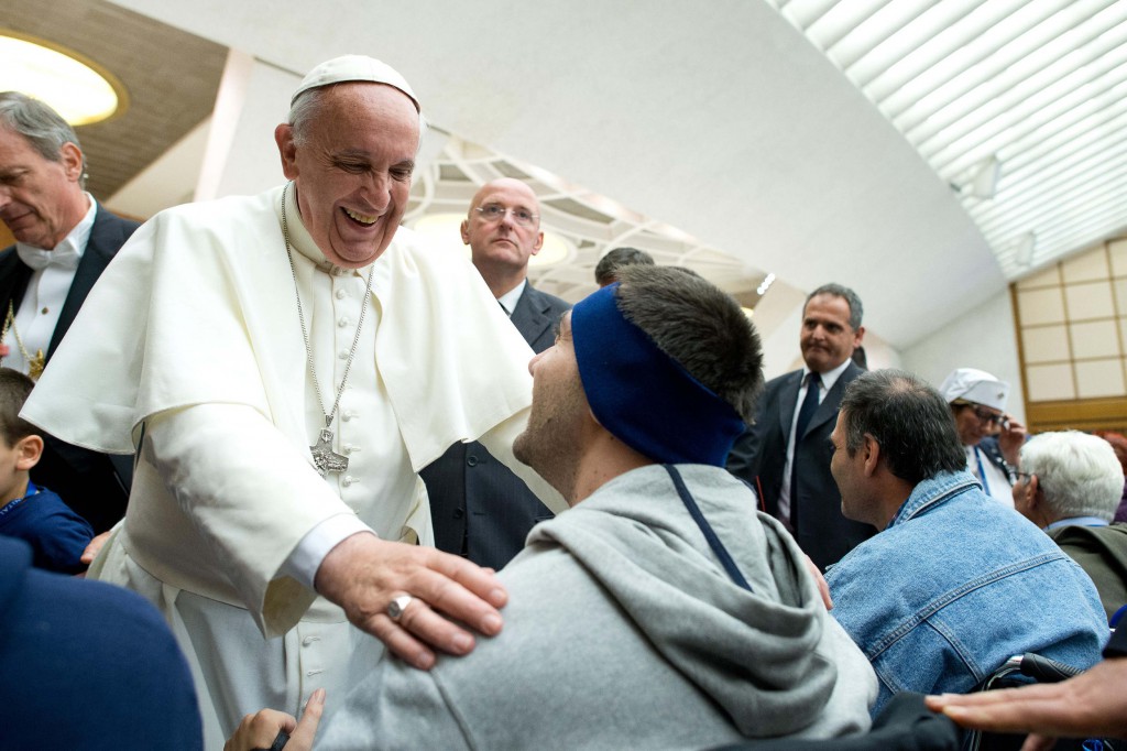 Pope Francis greets people in wheelchairs during a meeting with UNITALSI, an Italian Catholic association for the transportation of sick people to Lourdes and other Marian shrines, in Paul VI hall at the Vatican Nov. 9. (CNS photo/L'Osservatore Romano via Reuters)