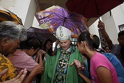 People greet Cardinal Theodore E. McCarrick, retired archbishop of Washington, after he celebrated Mass inside the partially destroyed Cathedral of the Transfiguration of Our Lord in Palo, Philippines, Nov. 17. Cardinal McCarrick celebrated Mass at the heavily damaged cathedral for victims of Typhoon Haiyan which came ashore Nov. 8 in the Philippines. (CNS photo/Bobby Yip, Reuters)