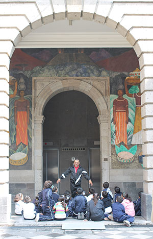A teacher explains a Diego Rivera mural to his students Oct. 12 at the Secretariat of Education Building in Mexico City. The children were not allowed to speak with priests on the pilgrimage because they attend public school. (J.D. Long-García/CATHOLIC SUN)