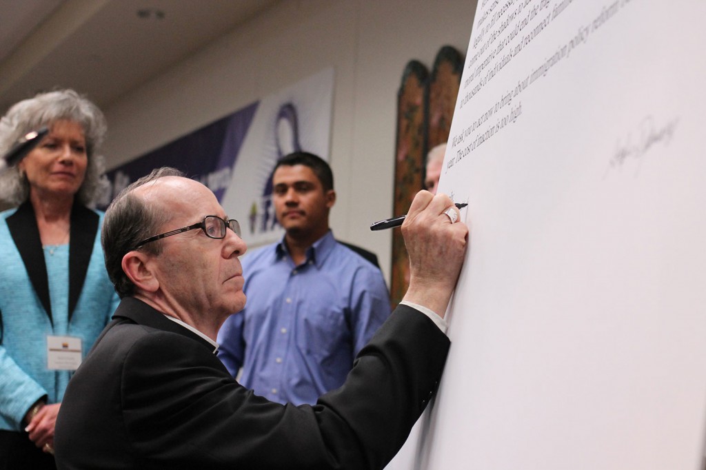 Bishop Thomas J. Olmsted leads a group signing of a letter to Congress that reads, in part, "We ask you to act now to bring about immigration policy reform before the end of this year. The cost of inaction is too high." (J.D. Long-Garcia/CATHOLIC SUN)