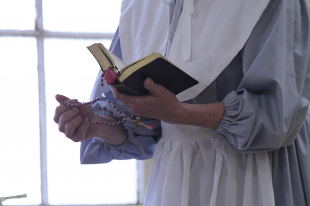 "Elizabeth Warren" of the Mayflower shows students how they prayed during the arduous journey to America. The assembly was through the diocesan Katzin Classical Music program. (Ambria Hammel/CATHOLIC SUN)