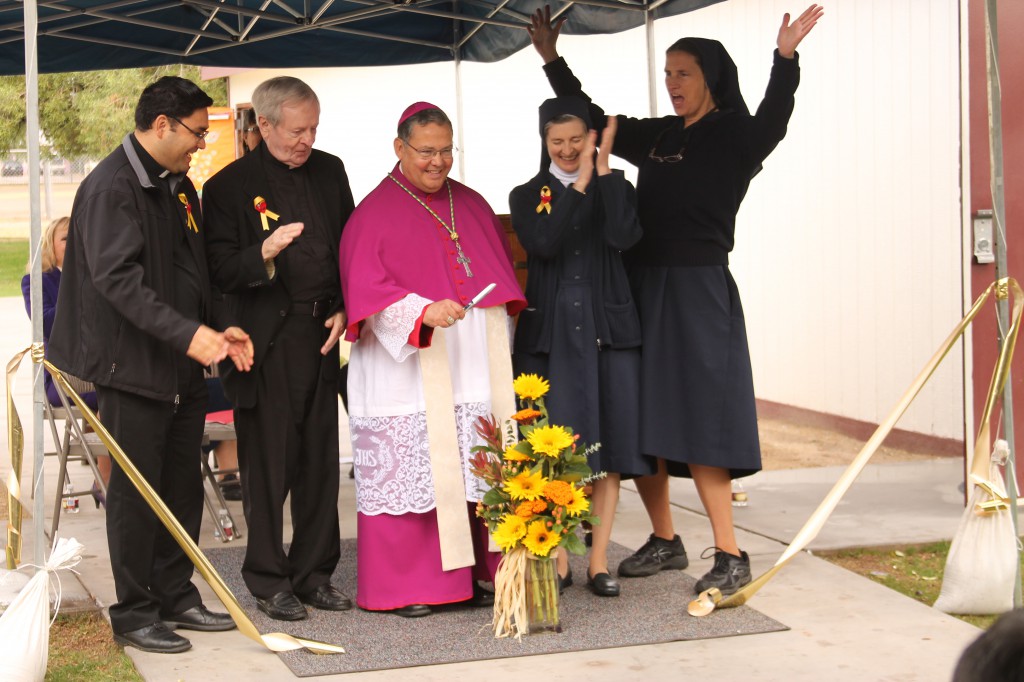 Sr. Julie Kubasak, D.C., right, principal of St. Vincent de Paul School, rejoices after Bishop Eduardo A. Nevares cuts the golden ribbon during a Nov. 23 blessing and dedication of an expanded campus. Fr. Jóse Jesus López, pastor, Vincentian Father Mike Boyle and Sr. Chis Maggi also joined in the celebration. (Ambria Hammel/CATHOLIC SUN)