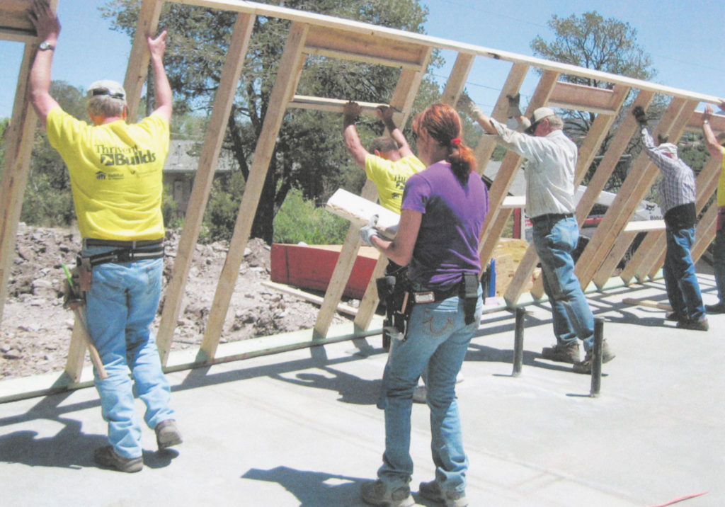 Sacred Heart parishioners, pictured here raising the walls of a house being built as part of Prescott Area Habitat for Humanity, have found healing through service. 