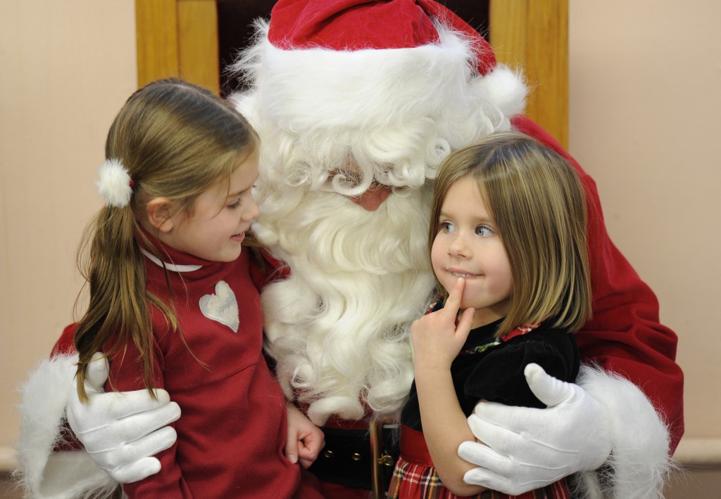 Nora Burroughs, left, and her sister Cate think about what they want for Christmas during the annual "Breakfast with Santa" at St. Joseph School in Auburn, N.Y., in this 2012 file photo. Santa Claus (Frank Basile) has been making a personal appearance at the school for 20 years. It's not too early to think about Christmas shopping. The time is now if you want your purchase to benefit a local parish. (CNS photo/Mike Crupi, Catholic Courier)