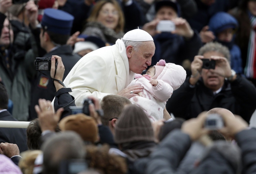 Pope Francis kisses a baby as he arrives for his weekly audience in St. Peter's Square at the Vatican Nov. 27. (CNS photo/Max Rossi, Reuters)