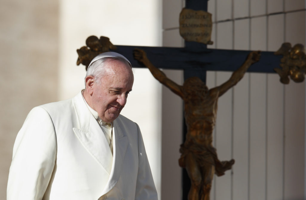 Pope Francis passes a crucifix as he walks down steps during his general audience in St. Peter's Square at the Vatican Dec. 4. (CNS photo/Paul Haring) 