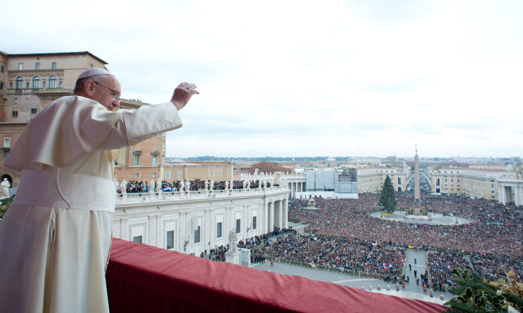 Pope Francis waves as he delivers his Christmas blessing "urbi et orbi" (to the city and the world) from the central balcony of St. Peter's Basilica at the Vatican Dec. 25. (CNS photo/L'Osservatore Romano via Reuters)