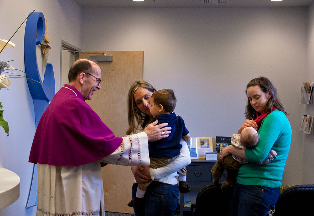 Bishop Thomas J. Olmsted greets mothers after the Dec. 8 blessing of Morning Star OB/GYN, a facility that stays true to Catholic teaching. (Kevin Theriault/CATHOLIC SUN)