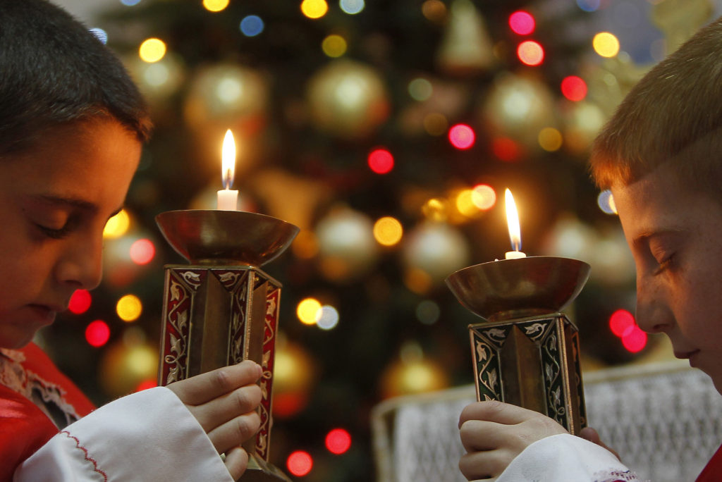 Two Iraqi boys hold candles as they pray for peace in Iraq and Syria during a 2012 Mass at a Chaldean Catholic church in Amman, Jordan. (CNS photo/Ali Jarekji, Reuters)
