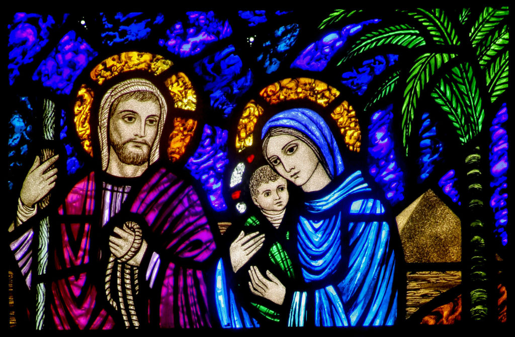 A detail of a stained-glass window from St. Edward’s Church in Seattle shows Jesus, Mary and Joseph on their flight into Egypt. The feast of the Nativity of Christ, a holy day of obligation, is celebrated Dec. 25. The feast of the Holy Family is marked Dec. 29. (Crosiers/CNS_