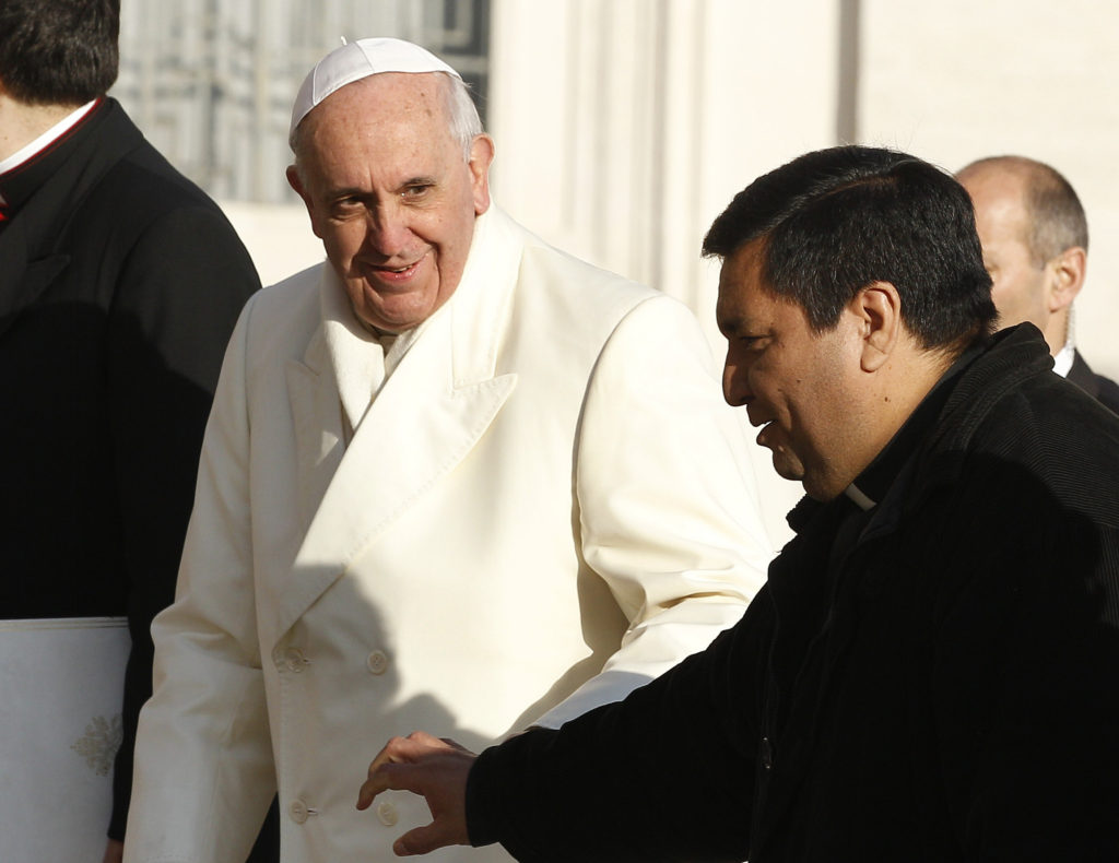 Pope Francis walks with Father Fabian Baez from Buenos Aires, Argentina, as he arrives to lead his general audience in St. Peter's Square at the Vatican Jan. 8. The pope caught site of the priest in the crowd and invited him to board the popemobile. (CNS photo/Paul Haring)