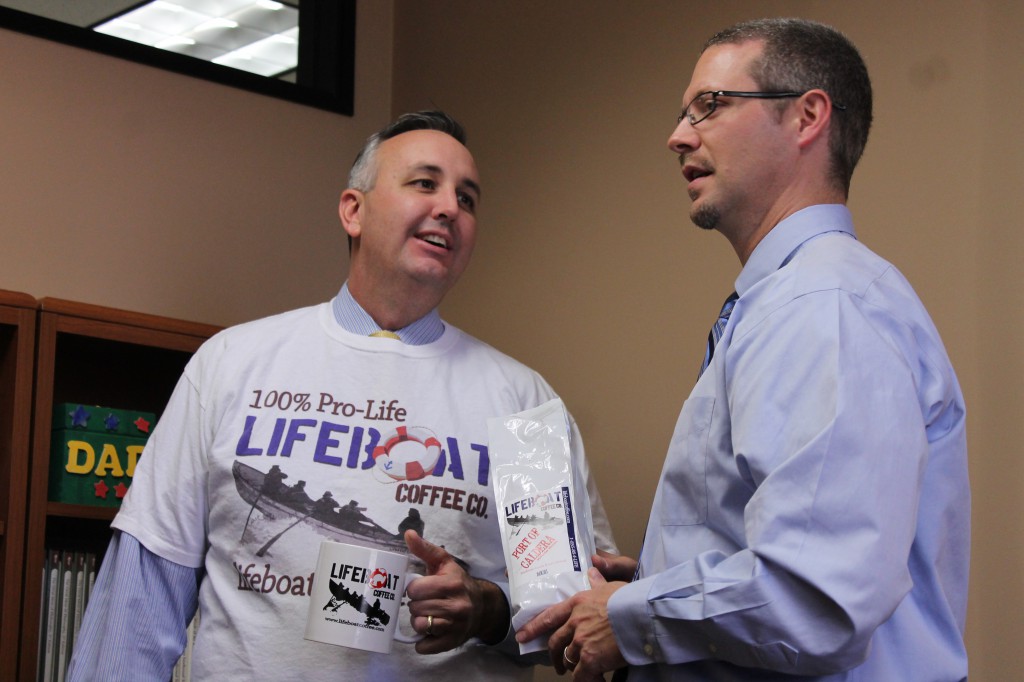 Ched Salasek discusses Lifeboat Coffee with Steve Greene, director of Kino Institute’s English programs. Coffee purchases help support pro-life organizations. (Joyce Coronel/CATHOLIC SUN)