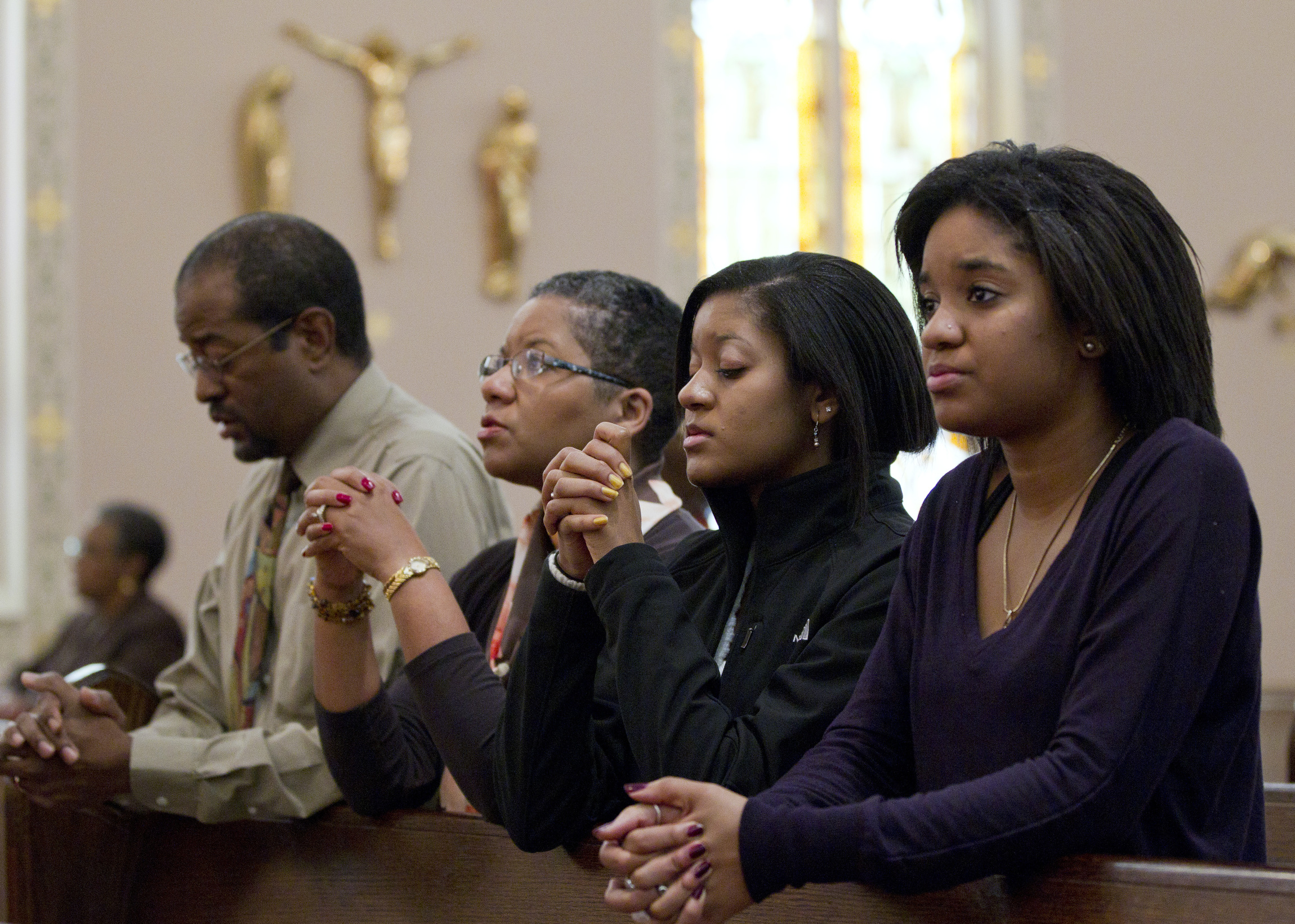 ...Joe, Desiree, Gabrielle and Alyssa - pray after arriving for Sunday Mass...