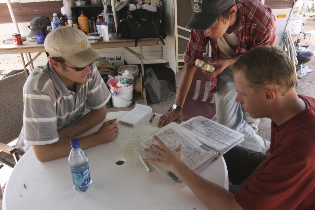 Walt Staton of Tucson, Ariz., Dane Rossman of New Jersey, and Jimmy Wells, of Tucson, volunteers with the humanitarian group No More Deaths, map out their Sept. 4, 2007, search for illegal immigrants left behind by their smugglers in the Sonoran Desert near the U.S.-Mexican border. (J.D. Long-Garcia, Catholic Sun file photo)