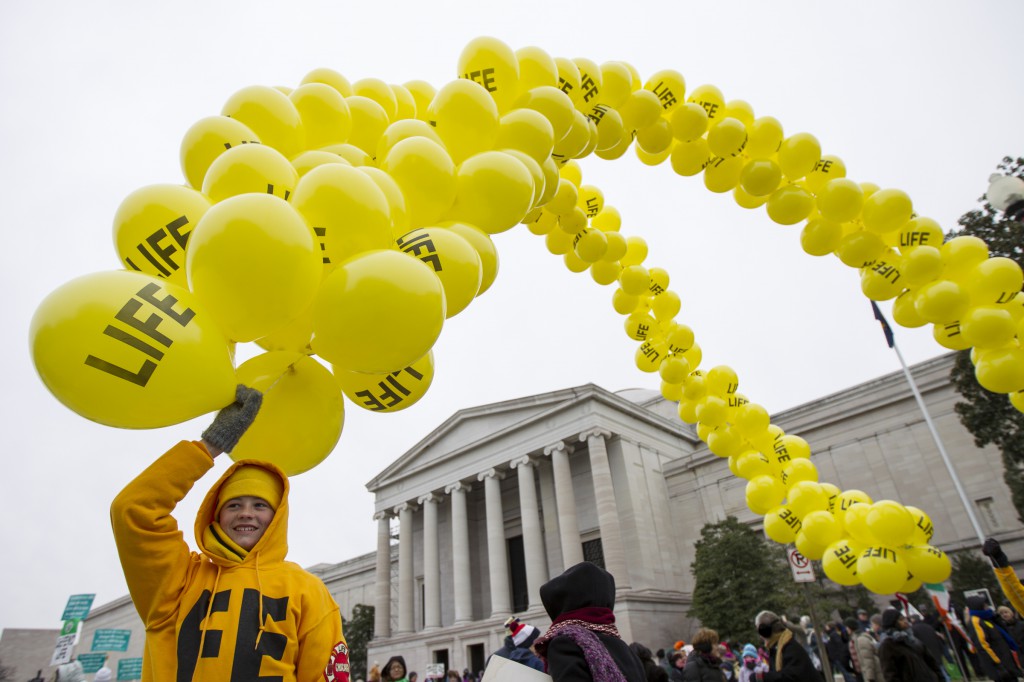 Peter Deziak, 15, of Chicago, holds a string of balloons during the March for Life in Washington Jan. 25, 2013. Look for live coverage of this year's march and other pro-life programming and sources for online discussions. (CNS photo/Daniel Sone)