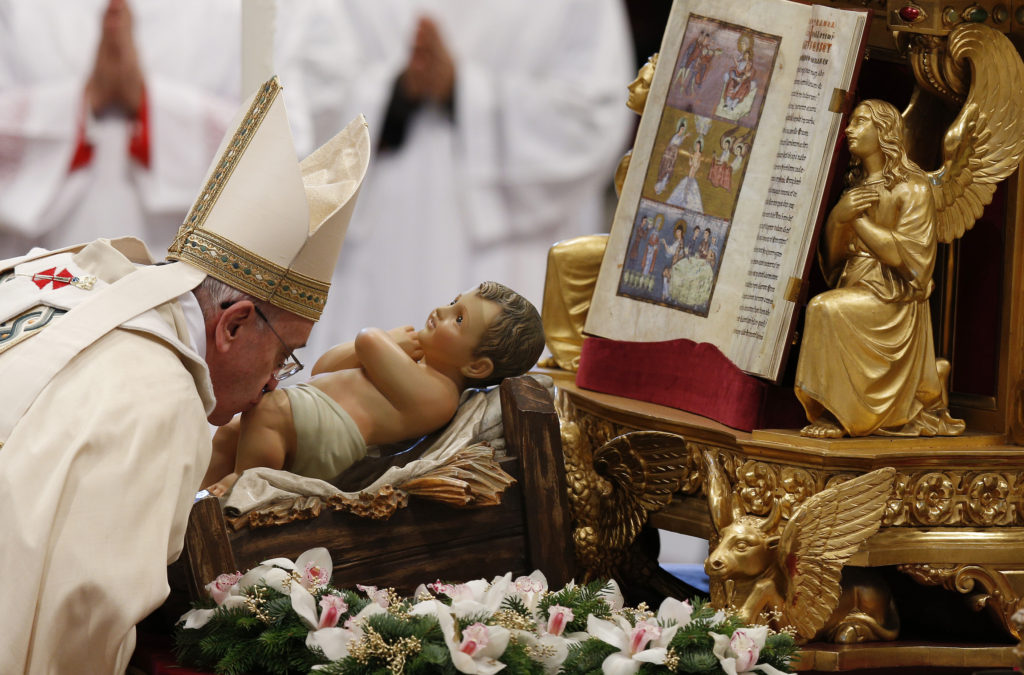Pope Francis kisses a figurine of the baby Jesus as he leaves after celebrating Mass on the feast of the Epiphany in St. Peter's Basilica at the Vatican Jan. 6. (CNS photo/Paul Haring) 