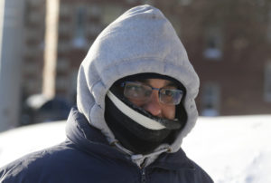 Ruebeam Mukherjee keeps his face covered Jan. 7 as he walks down the street during bitter cold temperatures in Detroit. (CNS photo/Rebecca Cook, Reuters)