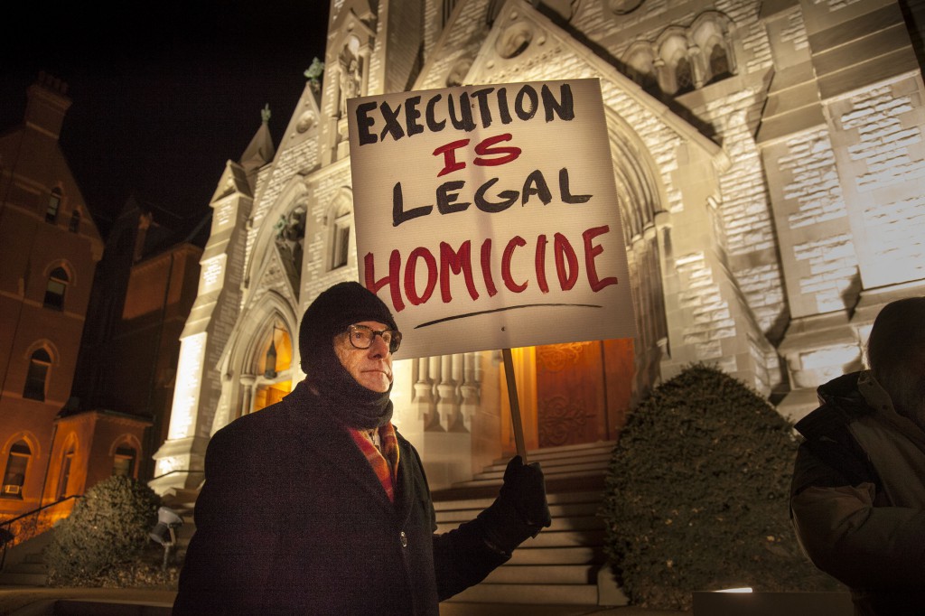 Christian Gohl holds a sign during a vigil held Jan. 28 outside St. Louis University College Church ahead of the execution of death-row inmate Herbert Smulls of St. Louis. Smulls, 56, was executed after midnight Jan. 29 at the penitentiary in Bonne Terre, Mo. Convicted in a 1991 murder committed during a jewelry store robbery, Smulls was granted a temporary stay of execution by the U.S. Supreme Court Jan. 28 but his appeals ran out and he was put to death by lethal injection. (CNS photo/Lisa Johnston, St. Louis Review)