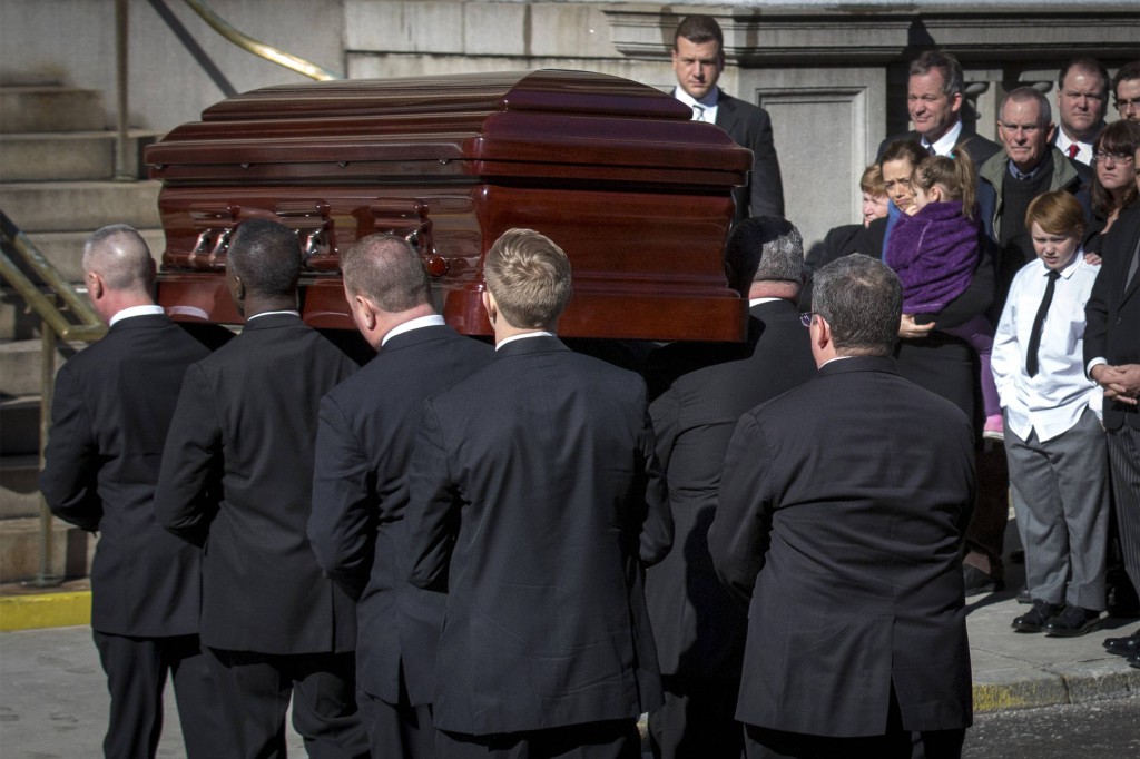 Mimi O'Donnell, former partner of actor Phillip Seymour Hoffman, holds their daughter Willa (in purple) next to their son, Cooper, as Hoffman's casket arrives for his Feb. 7 funeral Mass at St. Ignatius Loyola Church in New York. Hoffman, considered one of the leading actors of his generation, was found dead in his Manhattan apartment Feb. 2, in what police sources described as an apparent drug overdose. (CNS photo/Brendan McDermid, Reuters)