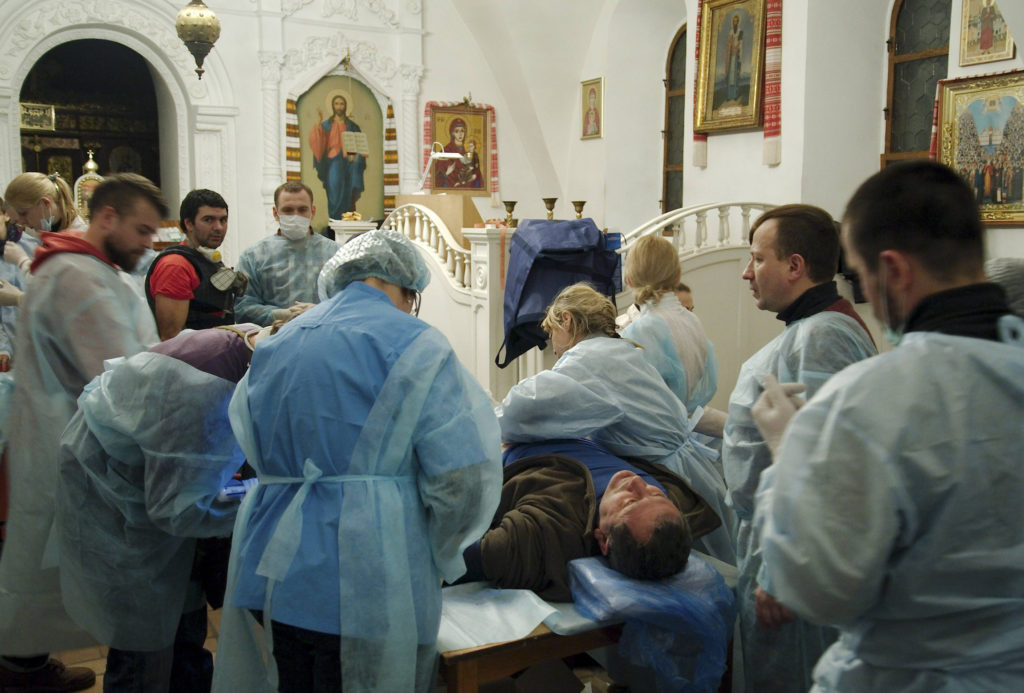 A man who was injured during clashes between anti-government protesters and riot police receives medical treatment inside St. Michael's Orthodox Cathedral in Kiev, Ukraine, Feb. 19. Ukraine's political crisis escalated sharply, with more than two dozen people killed and scores injured in violent, often fiery battles between demonstrators and police in Kiev. (CNS photo/Maks Levin, Reuters) (Feb. 19, 2014)