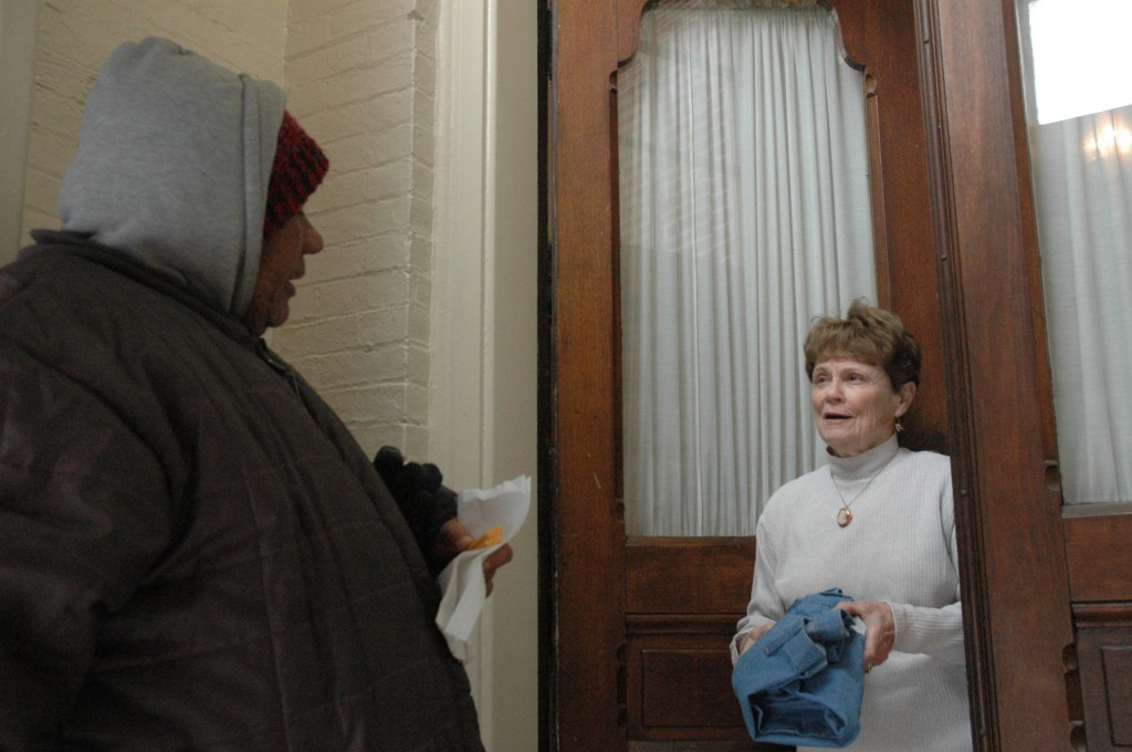 After giving a needy visitor a dish of lasagna and a pair of pants, volunteer Kathleen Murphy takes time to talk with him in late January at the Garden Door Ministry at St. John the Evangelist Church in Indianapolis. During what has been a brutal winter in Indiana, the Garden Door Ministry is one of several Catholic efforts reaching out to homeless people and others in need. (John Shaugnessy, CNS)