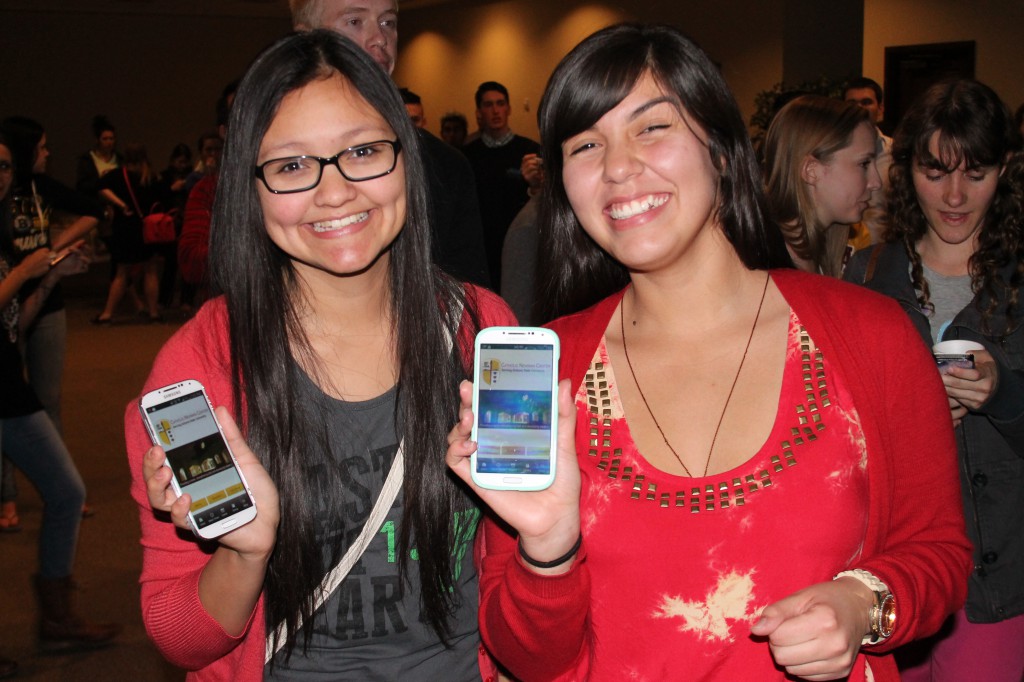 DeAnna Alvarez, 19, and Olivia Lopez, 20, show off the ASU Newman Catholic app on their smartphones. (Ambria Hammel/CATHOLIC SUN)