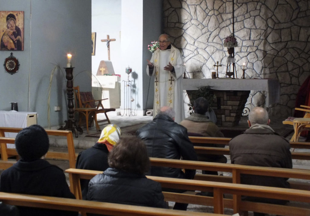 Fr. Frans Van der Lugt prays with fellow Catholics inside a monastery in Homs, Syria.