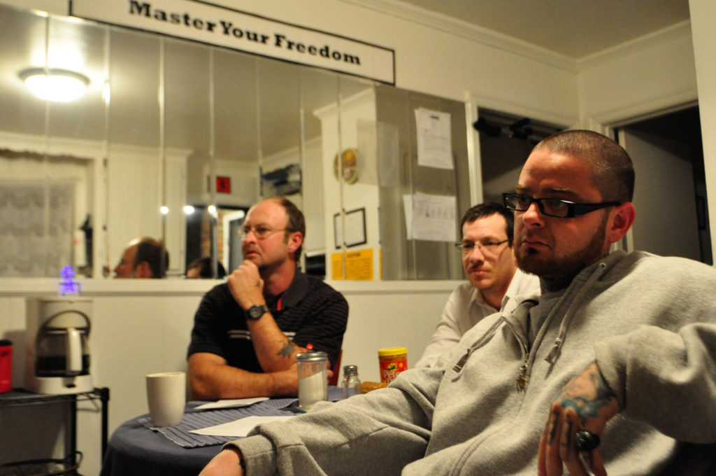 Jerry Webb, left, Jay Cody and Jesse Smith listen during a prayer service led by Deacon Ted Welsh, of St. Joseph Parish in Madison, Tenn. The deacon leads the weekly service for former prisoners who are making the transition back into society after their release. The prayer service was held at the Aphesis House, a halfway house in Madison, which several men in transition now call home. (CNS photo/Andy Telli, Tennessee Register)