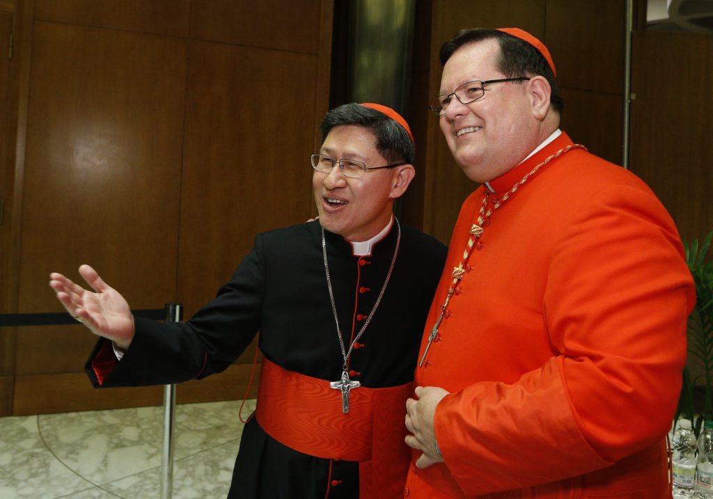 Cardinals Luis Tagle of Manila, Philippines, and Gerald Lacroix of Quebec exchange greetings during a reception for new cardinals in Paul VI hall at the Vatican Feb. 22. Pope Francis created 19 new cardinals during a consistory earlier in the day in St. Peter's Basilica. (CNS photo/Paul Haring) 