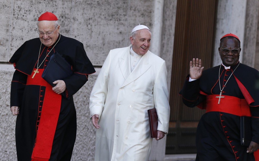 Pope Francis walks with Cardinals Angelo Sodano and Laurent Monsengwo Pasinya as he arrives to lead a meeting of cardinals in the synod hall at the Vatican Feb. 21. (CNS photo/Paul Haring)