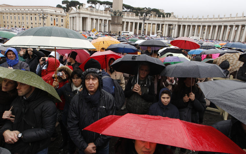 The crowd watches Pope Francis lead the Angelus from the window of his studio overlooking St. Peter's Square as rain falls at the Vatican March 2. The pope asked the world's Christians to pray for Ukraine and urged the parties involved in the conflict to engage in dialogue. (CNS photo/Paul Haring)