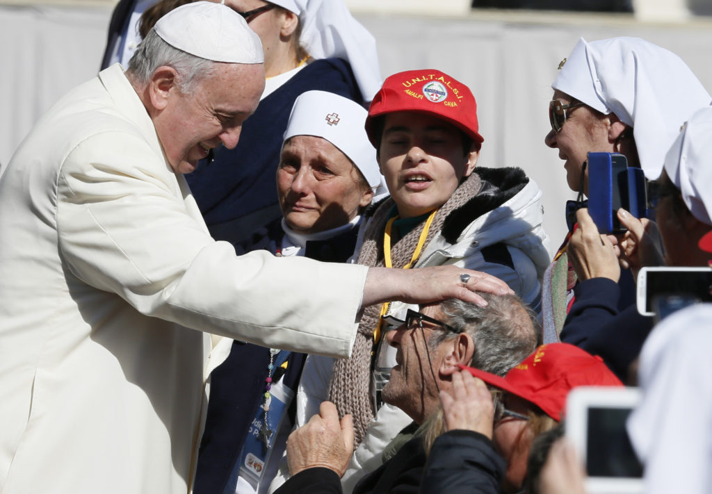Pope Francis blesses a man in a wheelchair as he greets the sick and disabled during his general audience in St. Peter's Square at the Vatican March 5. (CNS photo/Paul Haring)