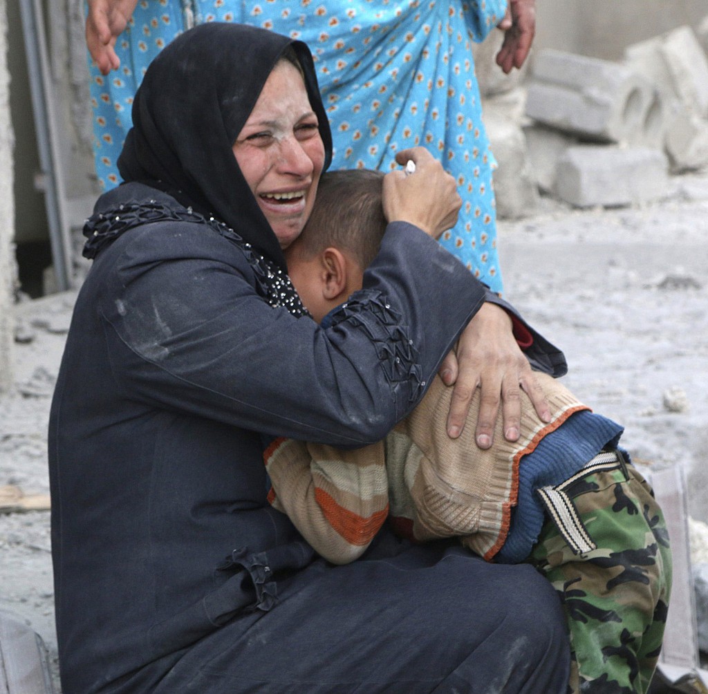A woman cries as she holds a boy at a site hit by what activists said was a barrel bomb dropped by forces loyal to Syrian President Bashar Assad in Aleppo, Syria, March 6. (CNS photo/Hosam Katan, Reuters)