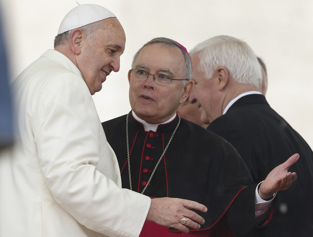 Pope Francis talks with Archbishop Charles J. Chaput of Philadelphia during his general audience in St. Peter's Square at the Vatican March 26. A delegation of government, religious and community leaders from Pennsylvania was meeting with Vatican officials to plan the Sept. 22-27, 2015, World Meeting of Families in Philadelphia. U.S. church and civil officials were preparing for Pope Francis' possible participation in the event. (CNS photo/Paul Haring)