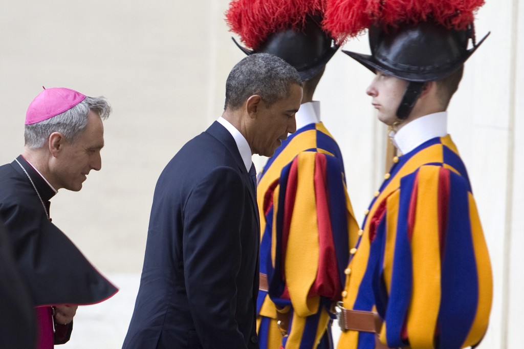 U.S. President Barack Obama walks past Swiss Guards in the San Damaso Courtyward as he arrives for a private audience with Pope Francis at the Vatican March 27. Also pictured is Archbishop Georg Ganswein, prefect of the papal household, who welcomed the pope upon his arrival. (CNS photo/Maria Grazia Picciarella) 