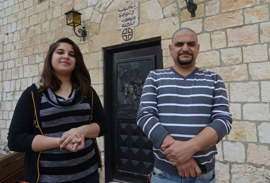 Jennifer Jozel, 17, a Catholic, stands outside her church, the Dormition of the Virgin, poses with her father, Samer, in the Israeli Christian village of Mi'ilya in Galilee, Feb. 24. She will join the air force in September and be assigned to the Iron Dome missile-defense system. (CNS photo/Debbie Hill) 