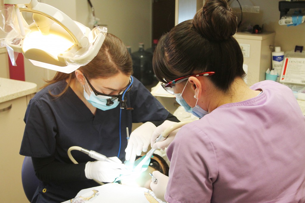 Emily Greenberg, a dental student with the Arizona School of Dentistry and Oral Health, and Berenice Burruel, a dental assistant, clean the teeth of a 7-year-old at St. Vincent de Paul’s dental clinic for children inside the Christown YMCA. Volunteer dentists and dental students provide some $3 million worth of free treatment every year. (Ambria Hammel/CATHOLIC SUN)