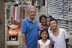 Emmanuel and Maria Rosevilla Margate pose for a photo with family members outside their home in Tacloban, Philippines, Feb. 10. The family huddled together in their block home Nov. 8, 2013, as Typhoon Haiyan made shambles of many homes in their community known as Barangay 54A. (CNS photo/Tyler Orsburn) 