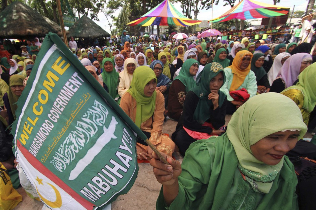A Moro woman holds a flag of the Moro Islamic Liberation Front during a gathering in Pikit, Philippines, March 27. The Philippines and its largest Muslim rebel group signed a final peace pact, ending about 40 years of conflict that has killed more than 1 20,000 people in the country's South. (CNS photo/Keith Bangcoco, Reuters) 