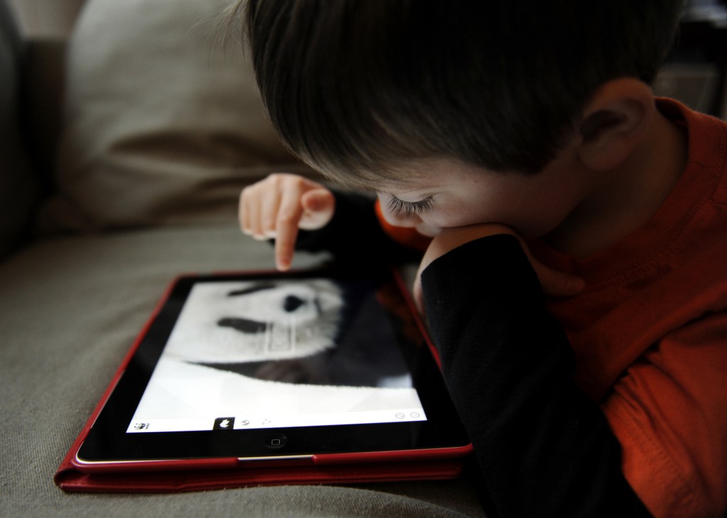 A boy uses the World Wildlife Fund app to take a closer look at pandas on an iPad in this 2013 file photo. The American Academy of Pediatrics issued a new policy statement Oct. 28 on the dangers of too much screen time for children. (CNS photo/Mike Crupi, Catholic Courier)