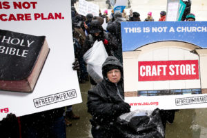 A supporter of women's rights and health holds a sign in front of the U.S. Supreme Court in Washington March 25. The Supreme Court heard oral arguments in lawsuits filed against a federal contraceptive mandate for employer health plans by Hobby Lobby Stores, Conestoga Wood Specialties on religious rights grounds. (CNS photo/Tyler Orsburn)