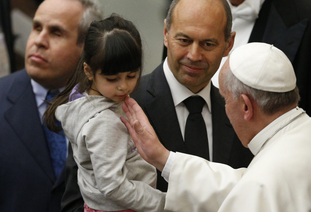 Pope Francis greets a young girl during an audience with people who are deaf or blind in Paul VI hall at the Vatican March 29. (CNS photo/Paul Haring)