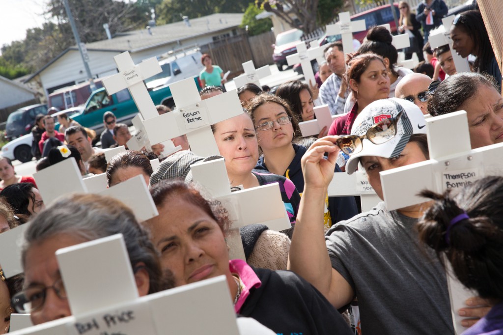 Several hundred people carrying crosses walk through their neighborhood in East Palo Alto, Calif., March 8 and pray the Stations of the Cross for an end to gang violence that is taking the lives of young people. In 2013, there were 16 homicides in San Mateo County, eight of those in East Palo Alto, a city with a population under 30,000. (CNS photo/Jose Aguirre, Catholic San Francisco)