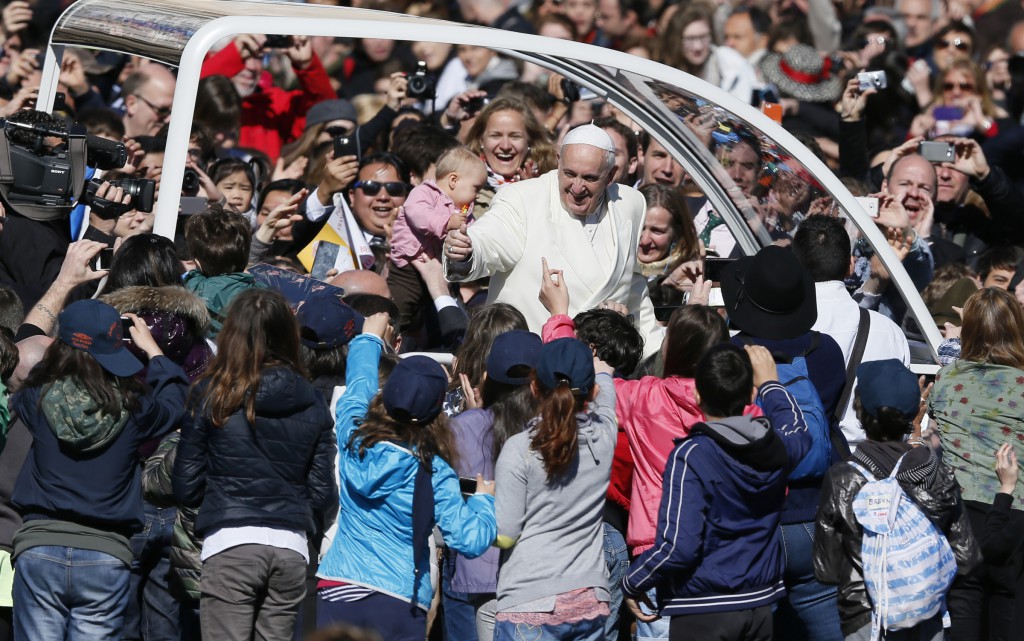 Pope Francis greets the crowd as he arrives to lead his general audience in St. Peter's Square at the Vatican April 16. (CNS photo/Paul Haring)