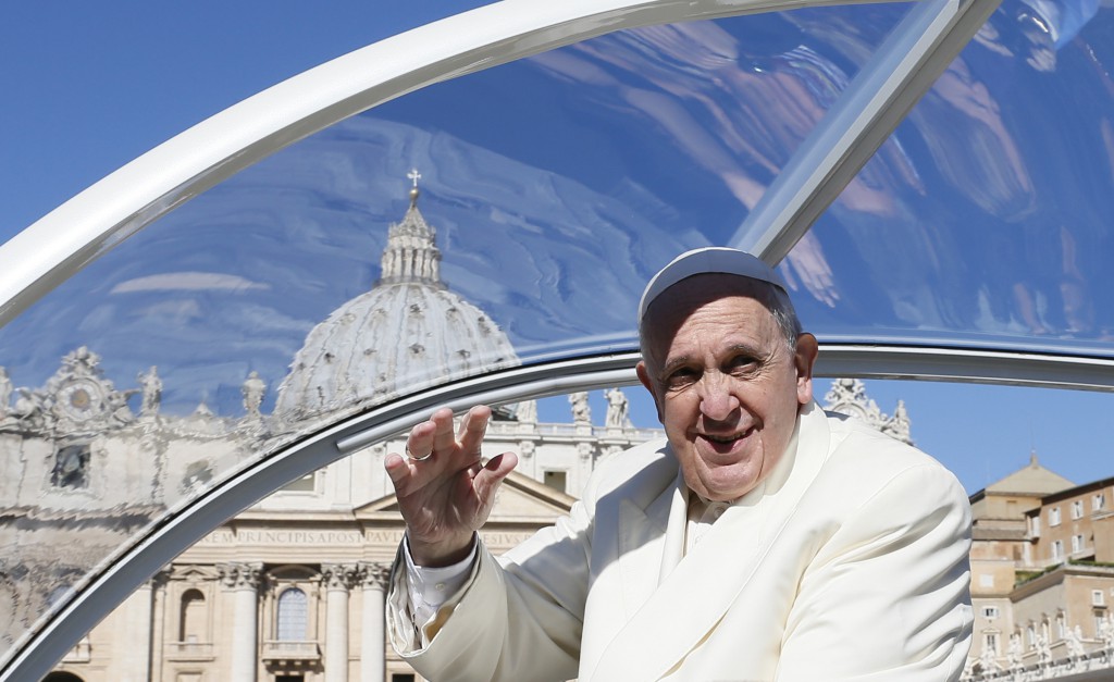 Pope Francis greets the crowd as he arrives to lead his general audience in St. Peter's Square at the Vatican April 16. (CNS photo/Paul Haring)