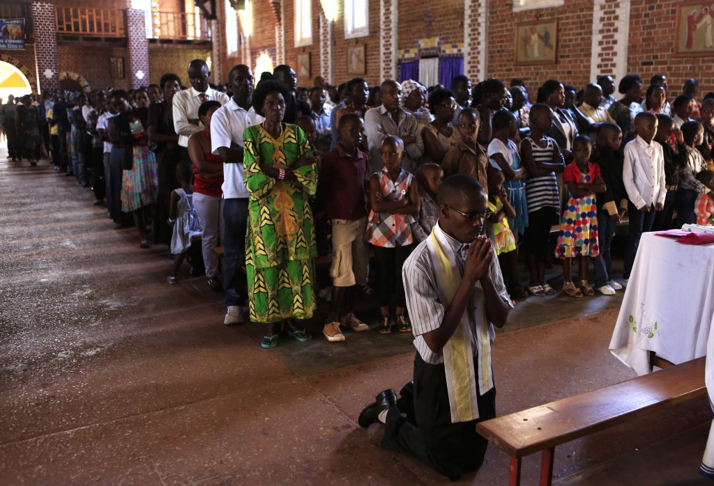 A man kneels in prayer during Mass at St. Famille Church in Kigali April 6, one day ahead of the commemoration of the 20th anniversary of the Rwandan genocide. An estimated 1 million people were murdered in acts of ethnic violence. (CNS photo/Noor Khamis, Reuters)