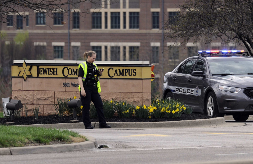 A police officer guards the entrance to the scene of a shooting at the Jewish Community Center of Greater Kansas City in Overland Park, Kan., April 13. A gunman opened fire at two Jewish facilities near Kansas City that day, killing three people, police said. (CNS photo/Dave Kaup, Reuters) 