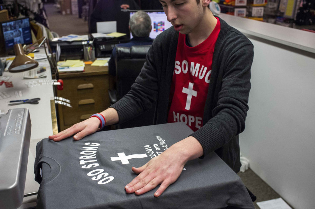 Nathan Senff makes T-shirts April 2 to remember victims of the Oso mudslide near Arlington, Wash. Catholic Community Services of Western Washington and Immaculate Conception Parish in Arlington were seeking donations and continued to help those affected by the mudslide, about 55 miles north of Seattle. (CNS photo/Max Whittaker, pool via Reuters)