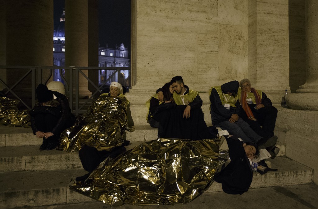 People assisting with the canonization of Sts. John XXIII and John Paul II sleep outside the colonnade in St. Peter's Square at the Vatican in the early morning April 27. (CNS photo/Paul Haring)