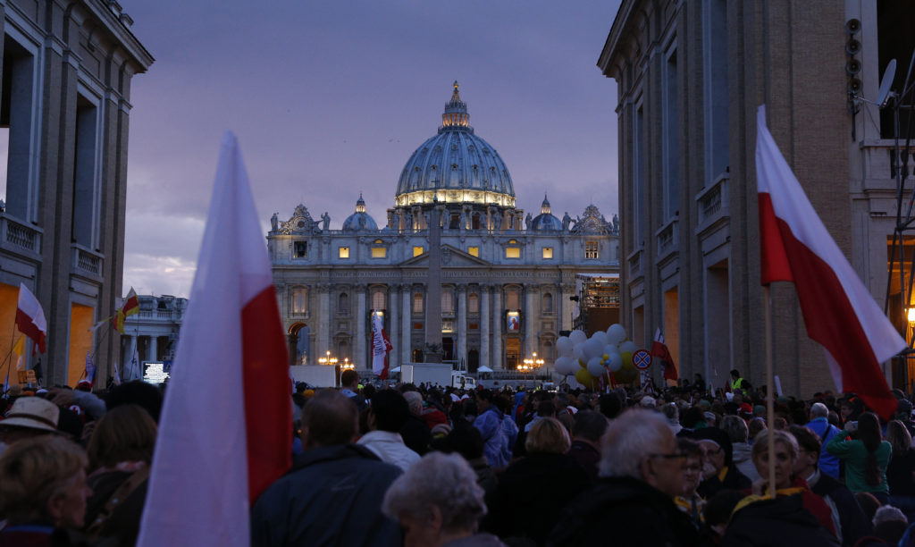 Pilgrims wait on Via della Conciliazione outside St. Peter's Square at the Vatican April 26, the eve of the canonization of Sts. John XXIII and John Paul II. (CNS photo/Paul Haring)